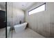 Stylish bathroom showcasing a modern soaking tub and neutral tiled walls at 1538 W Wagon Wheel Dr, Phoenix, AZ 85021