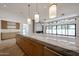 Modern kitchen with a large island, pendant lights, and a view to the Gathering room at 1538 W Wagon Wheel Dr, Phoenix, AZ 85021