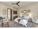 Comfortable bedroom with a sitting area, a ceiling fan, stylish decor, and doorway to a refreshment area at 16119 N Desert Fox Pkwy, Fountain Hills, AZ 85268