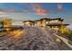 Paver driveway guiding to a modern home, complemented by desert landscaping and soft exterior lighting at dusk at 16119 N Desert Fox Pkwy, Fountain Hills, AZ 85268