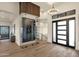 Elegant foyer with a glass-enclosed wine cellar and contemporary lighting fixture at 16119 N Desert Fox Pkwy, Fountain Hills, AZ 85268