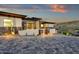 Striking front entrance highlighting stone pillars, a contemporary front door, and soft, inviting landscape lighting at 16119 N Desert Fox Pkwy, Fountain Hills, AZ 85268