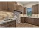 Well-organized laundry room with ample cabinet space, granite countertops, stone backsplash, and a utility sink at 16119 N Desert Fox Pkwy, Fountain Hills, AZ 85268