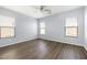 Spacious bedroom with three windows and wood-look flooring at 19664 W Woodlands Ave, Buckeye, AZ 85326