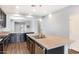 Kitchen island featuring a double sink, stainless steel dishwasher, and stylish pendant lighting at 19664 W Woodlands Ave, Buckeye, AZ 85326