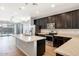 Modern kitchen featuring stainless steel appliances, dark cabinetry, and a large kitchen island at 19664 W Woodlands Ave, Buckeye, AZ 85326