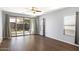 Bright living room with sliding glass doors to backyard, window, and wood-look flooring at 19664 W Woodlands Ave, Buckeye, AZ 85326