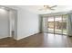 Bright living room with sliding glass doors to backyard, ceiling fan, and wood-look flooring at 19664 W Woodlands Ave, Buckeye, AZ 85326