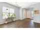 Bright living room with hardwood floors, large windows, chandelier, and open entry way at 19664 W Woodlands Ave, Buckeye, AZ 85326