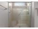 Clean shower with a clear glass enclosure, built in bench, and multiple shower heads at 19722 N Regents Park Dr, Surprise, AZ 85387