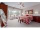 Comfortable bedroom with large windows, ceiling fan, and cozy sitting area at 19722 N Regents Park Dr, Surprise, AZ 85387