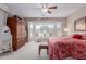 Spacious bedroom featuring bright windows, ceiling fan, and a wooden armoire at 19722 N Regents Park Dr, Surprise, AZ 85387