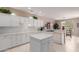 Bright kitchen featuring white cabinets, quartz countertops, an island, and stainless steel appliances at 19722 N Regents Park Dr, Surprise, AZ 85387