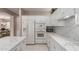 Well-lit kitchen with white cabinetry, quartz countertops, an island, and stainless steel appliances at 19722 N Regents Park Dr, Surprise, AZ 85387
