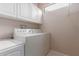 Efficient laundry room includes white appliances and ample storage space at 19722 N Regents Park Dr, Surprise, AZ 85387