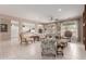 Spacious living room with tile flooring, large windows, a ceiling fan, and an open view of the kitchen at 19722 N Regents Park Dr, Surprise, AZ 85387