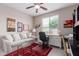 Comfortable office features a ceiling fan, desk, sofa, and large window for natural light at 19722 N Regents Park Dr, Surprise, AZ 85387