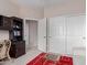 Office space featuring dark cabinets, sliding closet doors, and a striped white sofa at 19722 N Regents Park Dr, Surprise, AZ 85387