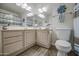 Bright bathroom featuring tiled floors, a modern toilet, and a vanity with mirrors and decorative accents at 2046 E Downing St, Mesa, AZ 85213