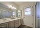 Bathroom featuring double sinks, walk-in shower, and an exterior entrance at 2046 E Downing St, Mesa, AZ 85213