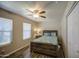 Comfortable bedroom with a wood-framed bed, ceiling fan, and large window at 2046 E Downing St, Mesa, AZ 85213