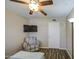 Relaxing bedroom space with a comfortable chair, ceiling fan, and mounted television at 2046 E Downing St, Mesa, AZ 85213