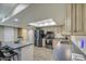 Bright kitchen featuring a skylight, stainless steel appliances, island seating, and neutral cabinetry at 2046 E Downing St, Mesa, AZ 85213