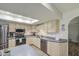 Bright kitchen with stainless steel appliances and a skylight illuminating the neutral countertops and cabinets at 2046 E Downing St, Mesa, AZ 85213