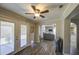 Bright sunroom with wood-look tile, double doors to the patio, and view to the kitchen and living room at 2046 E Downing St, Mesa, AZ 85213