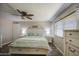 Bright main bedroom with wood floors, ceiling fan, large window, and white furniture at 2046 E Downing St, Mesa, AZ 85213