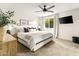Bright bedroom features a ceiling fan, mounted TV, neutral tones and a window at 2418 E Hermosa Dr, Tempe, AZ 85282