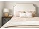 An interior shot of a bedroom, featuring a soft upholstered headboard, reading lamp, and side table at 2418 E Hermosa Dr, Tempe, AZ 85282