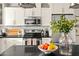 Close up on modern kitchen boasting stainless steel appliances and black countertops with a fruit bowl on the island at 2418 E Hermosa Dr, Tempe, AZ 85282