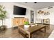 Stylish living room with a large TV, modern console, and natural light, creating a cozy and inviting space at 2418 E Hermosa Dr, Tempe, AZ 85282
