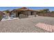 A spacious backyard with gravel, featuring a built-in barbecue and chairs for comfortable outdoor living at 24229 W Tonto St, Buckeye, AZ 85326