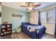 Cozy bedroom featuring hardwood floors, ceiling fan, and window with curtains at 24229 W Tonto St, Buckeye, AZ 85326