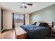 Bedroom with dark-stained hard wood floors, ceiling fan, and bright window at 24229 W Tonto St, Buckeye, AZ 85326