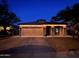 Charming single-story home featuring a two-car garage and nicely landscaped front yard at night at 24229 W Tonto St, Buckeye, AZ 85326