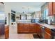 Spacious kitchen with tile floors, warm wood cabinets, granite countertops, and stainless steel appliances at 24229 W Tonto St, Buckeye, AZ 85326