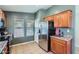 Kitchen with stainless steel refrigerator, tile floors, and warm wood cabinets at 24229 W Tonto St, Buckeye, AZ 85326