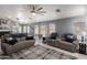 Spacious living room with marble floors, comfortable seating, and a stylish ceiling fan at 24648 N 40Th Ln, Glendale, AZ 85310