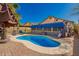 Sparkling backyard pool featuring a brick-paved deck, sun loungers, and shade umbrella at 24648 N 40Th Ln, Glendale, AZ 85310