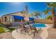Beautiful backyard pool area with lounge chairs, shade umbrella, and lush tropical landscaping at 24648 N 40Th Ln, Glendale, AZ 85310
