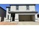 Two-story home featuring a wide two car garage and a gray stucco facade, complemented by a well manicured lawn at 29775 N Oak Dr, Florence, AZ 85132