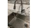 Close-up on a modern kitchen sink with stainless steel features and granite countertops with subway tile backsplash at 30178 N Coral Bean Dr, San Tan Valley, AZ 85143
