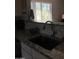 Kitchen sink with granite countertops, tiled backsplash, and a view to the yard with plants and palm tree at 30178 N Coral Bean Dr, San Tan Valley, AZ 85143