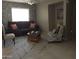 Cozy living room with neutral decor, including a dark sofa with patterned rug and chair at 30178 N Coral Bean Dr, San Tan Valley, AZ 85143