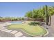 Landscaped backyard featuring a putting green and swimming pool, perfect for outdoor relaxation at 30374 N 124Th Dr, Peoria, AZ 85383