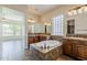 Bathroom featuring a soaking tub, dual sinks, dark wood cabinets, and tile floors at 30374 N 124Th Dr, Peoria, AZ 85383