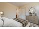 This bedroom showcases a neutral color palette, complemented by a decorative mirror and dresser at 30374 N 124Th Dr, Peoria, AZ 85383